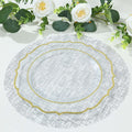 Elegant clear glass plate with gold trim on a textured gray placemat.