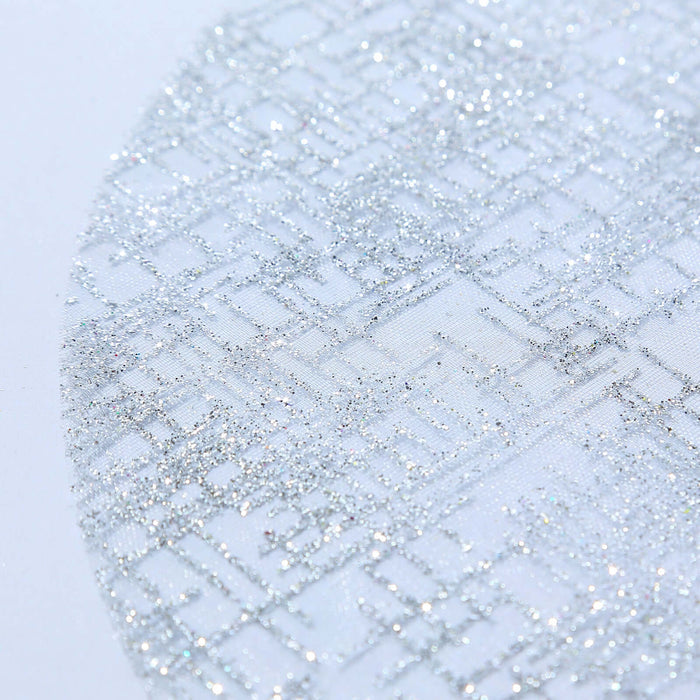 Silver glitter fabric with intricate pattern detail.