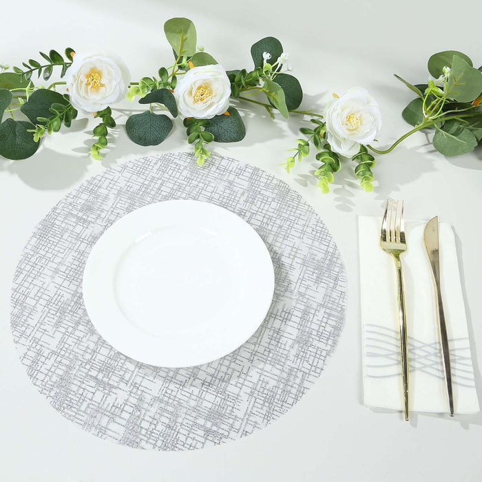 Decorative table setting with a white plate, silver utensils, and floral accents.