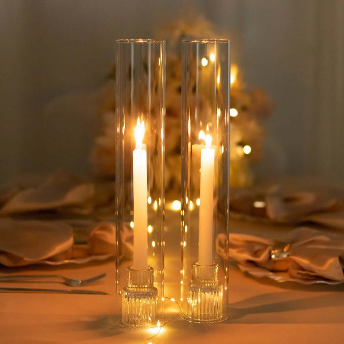 Elegant glass candle holders with lit candles, set on a beautifully decorated table.