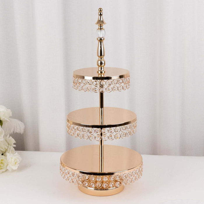 Gold three-tier cake stand with crystal accents, perfect for elegant displays.