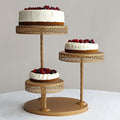 Three-tiered cake stand with white cakes topped with fresh berries.