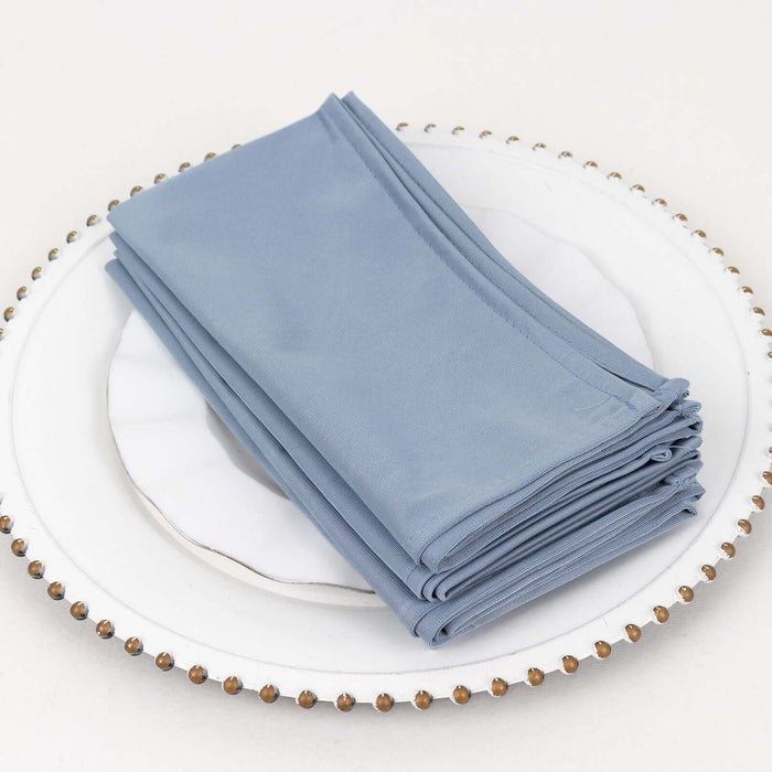 Stack of light blue cloth napkins neatly arranged on a decorative plate.
