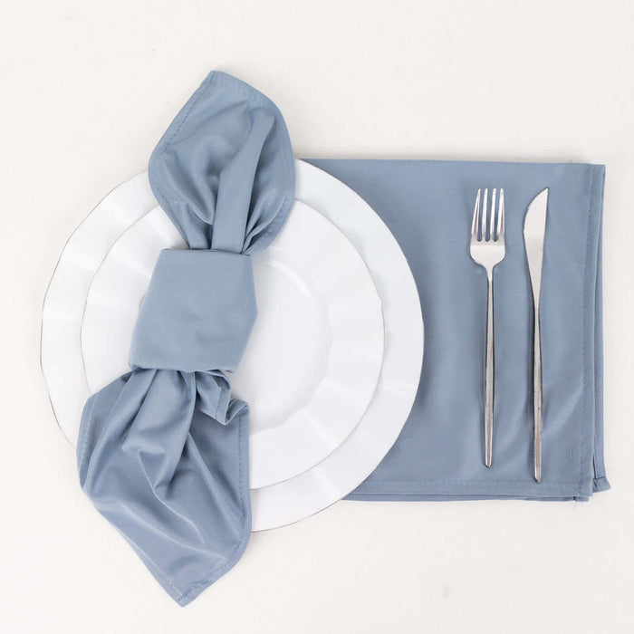 Elegant table setting with blue napkin, plates, and silverware.