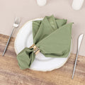 Green napkin elegantly styled on a plate with a gold napkin ring.