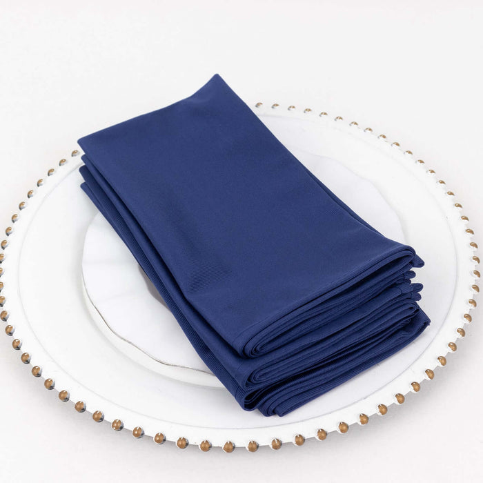 Navy blue cloth napkins stacked on a decorative plate