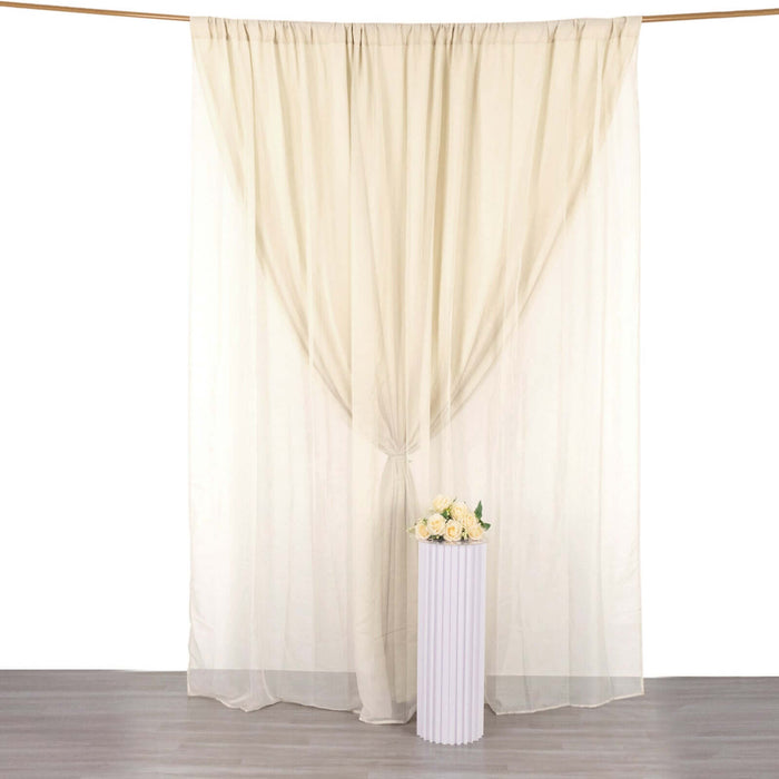 Sheer curtains with a decorative vase of flowers on a pedestal.