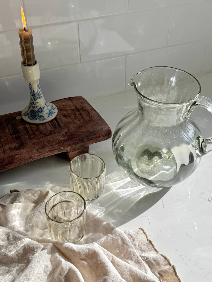 Clear glass fluted pitcher with loop handle, rounded belly, and arched spout