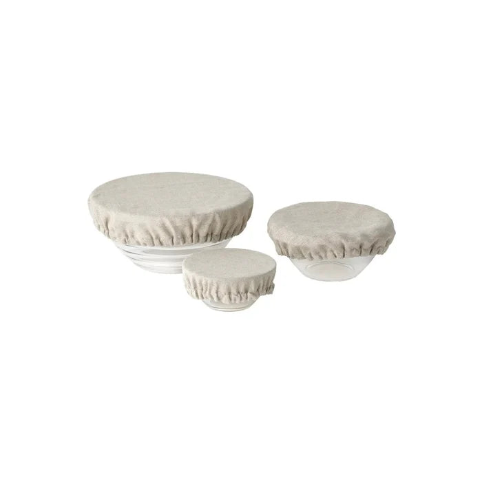 Three round linen bowl covers with gathered elastic edge, light beige, on bowls