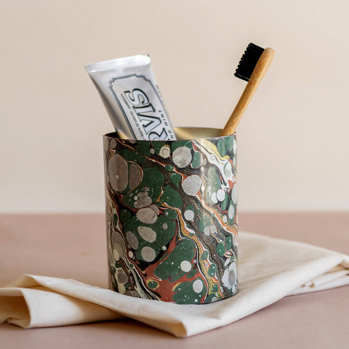 Marbled everything pot with wooden brush and wrapped items inside