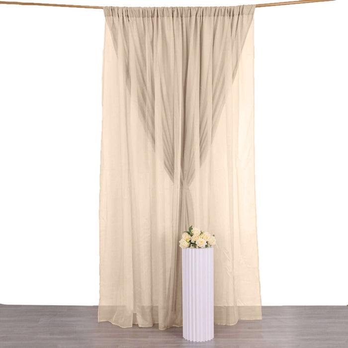 Sheer beige curtain draped elegantly with flowers in a vase below.