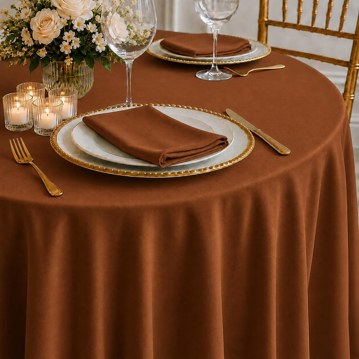 Cinnamon brown round tablecloth draped over a dining table setting.