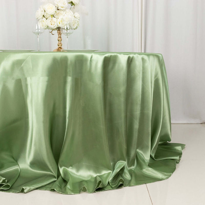 Green satin tablecloth draped elegantly over a table with floral centerpiece.