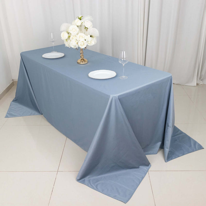 Elegant blue tablecloth draped over a table set with plates and a floral centerpiece.