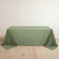Green tablecloth draped elegantly over a table on a light wooden floor.