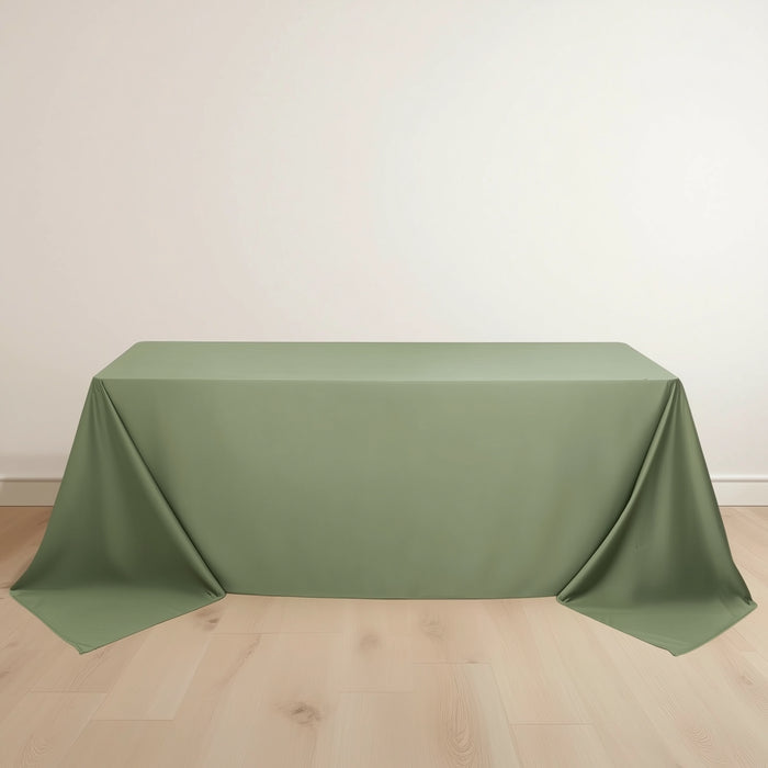 Green tablecloth draped elegantly over a table on a light wooden floor.