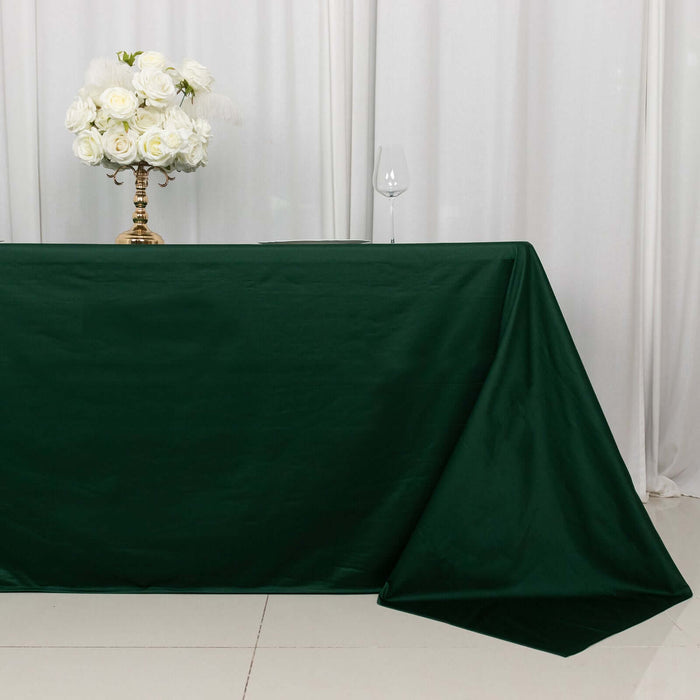 Elegant green tablecloth draped on a table with a floral centerpiece and wine glass.