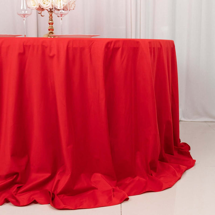 Red tablecloth draped elegantly over a round table in a styled setting.