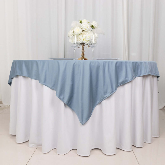 Elegant blue tablecloth draped over a white table with floral centerpiece.
