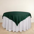 Green tablecloth draped over a round table with a white skirt.