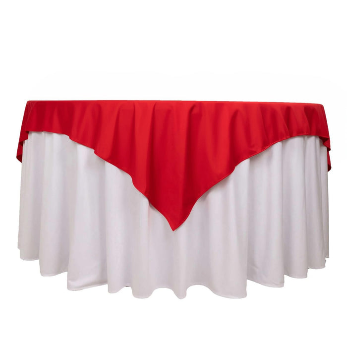 Red tablecloth draped over a white table for festive occasions.