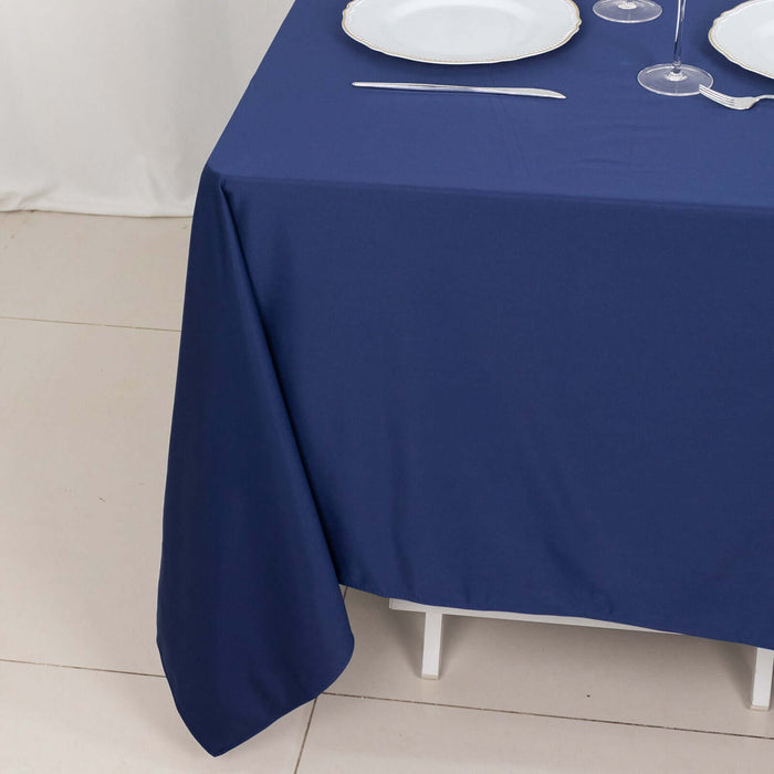 Navy blue tablecloth draped elegantly over a table with white plates and glassware.