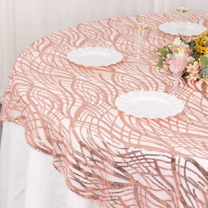Rose gold lace tablecloth with elegant design on a round table.