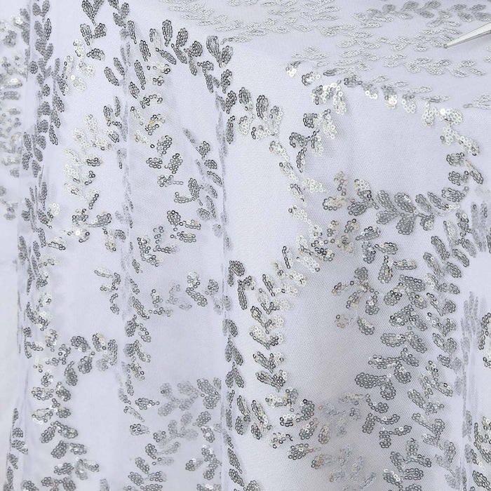 Silver sequin tablecloth with a leaf pattern on a white background.