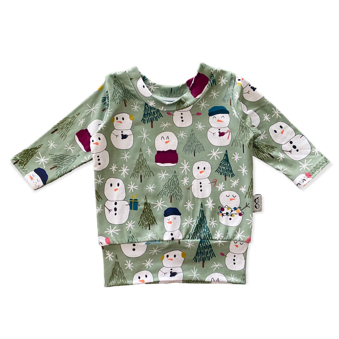 Snowman Print Lounge Set featuring a long-sleeve pullover and matching leggings with a playful snowman and winter tree design on a soft green background. Handmade for babies and toddlers, perfect for holiday celebrations and seasonal wear.
