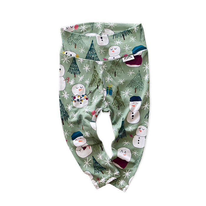 Snowman Print Lounge Set featuring a long-sleeve pullover and matching leggings with a playful snowman and winter tree design on a soft green background. Handmade for babies and toddlers, perfect for holiday celebrations and seasonal wear.