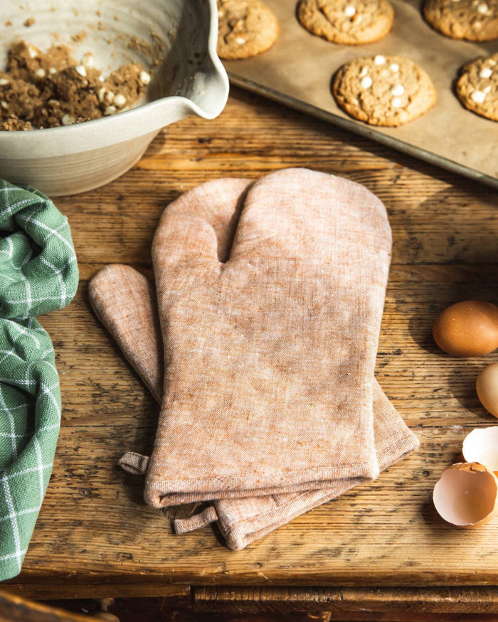 Folded light tan linen oven mitt with thumb and textured washed fabric